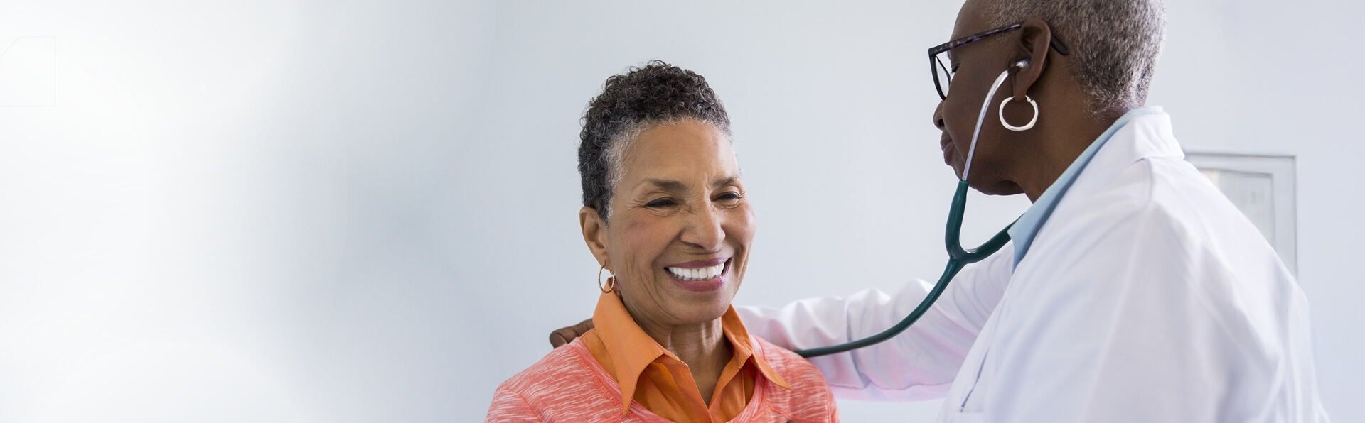 A provider listening to a patient's lungs.