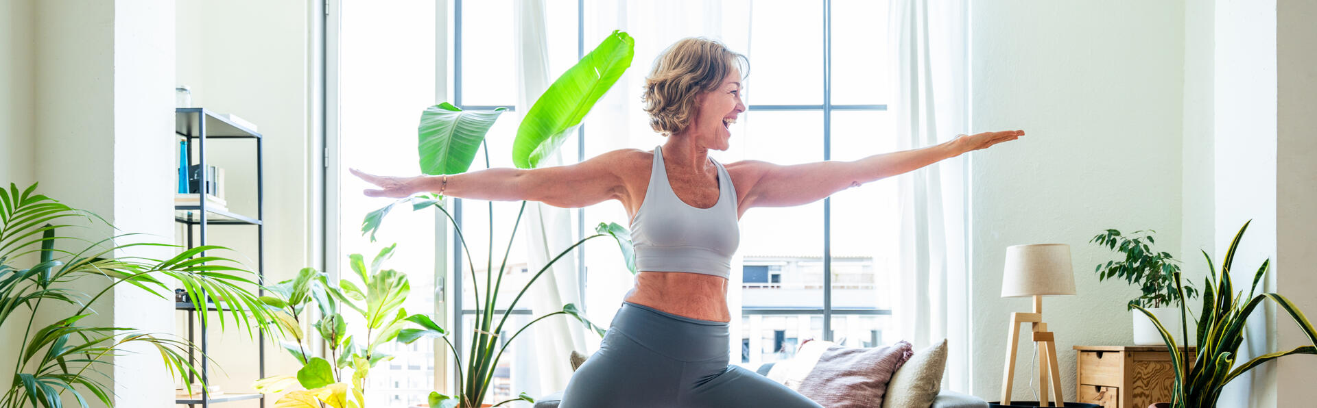 Beautiful mature senior woman at home, domestic life and leisure moments - 50-60 years old pretty female adult training in the living room